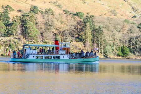Cruise Ship sailing in Brathay Bay with beautiful mountains in the backの写真素材