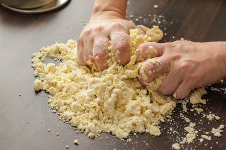 Mixing fresh Dough with a hands on the tableの写真素材