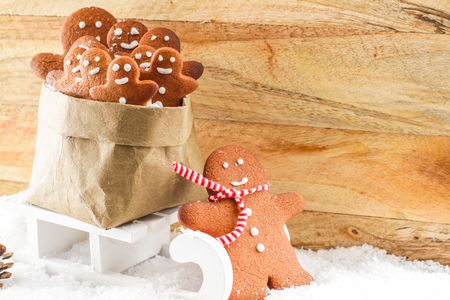 Gingerbread man pulling sled with a bag of small cookiesの写真素材