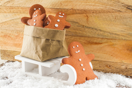 Gingerbread man pulling sled with a bag of small cookiesの写真素材
