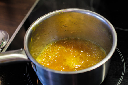 Yellow sauce in the metal sause pan  boilingの写真素材