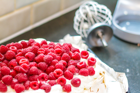 Fresh Raspberry Meringue on the table with the whisk alongsideの写真素材