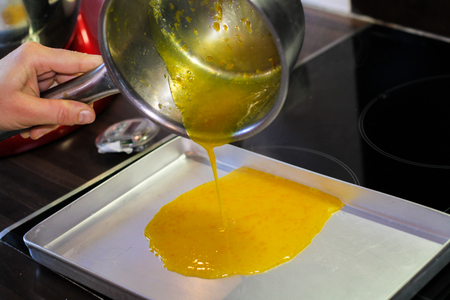 Pouring down on to baking tray orange sauseの写真素材