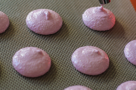 Piping out macaron mixture on to the baking trayの写真素材
