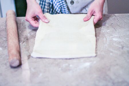 Rolloing freshly made dough on the tableの写真素材