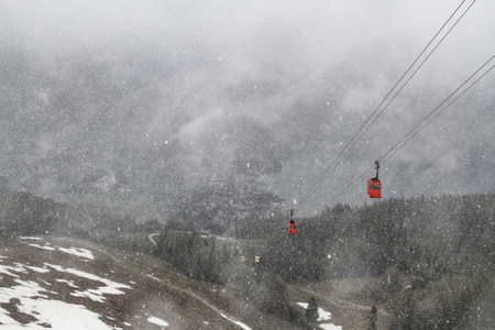Cable carts in the snow over the mountainの写真素材
