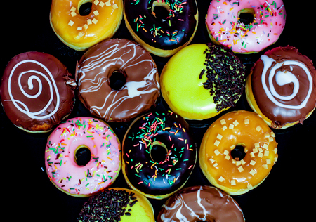 Tasty and deliciously looking donuts on black backgroundの写真素材