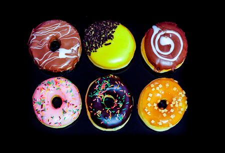 Tasty and deliciously looking donuts on black backgroundの写真素材
