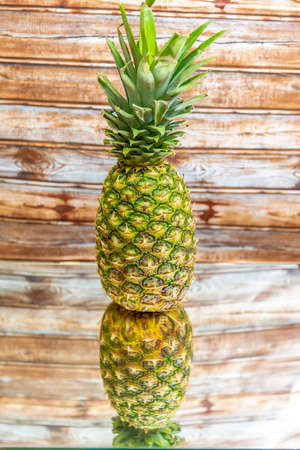 beautiful pineapple with a nice reflection wooden backgroundの写真素材