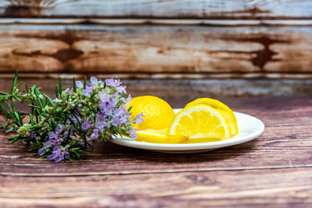 lemons and rosemary flowers on wooden backgroundの写真素材