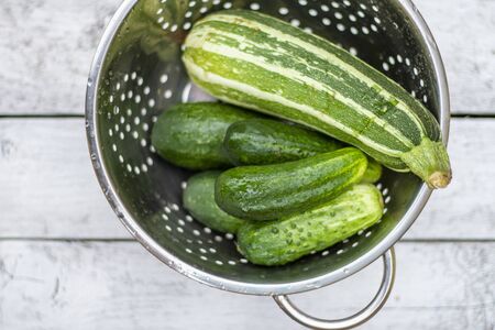 Fresh cucumbers and zucchini on a white boardの写真素材