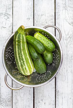 Fresh cucumbers and zucchini on a white boardの写真素材