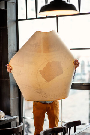 Creative architect looking on the big architectural drawings in front of the big window