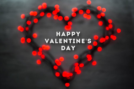Heart with red blurred lights on wooden dark background. Valentines day card conceptの写真素材