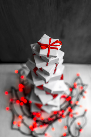 A pile of gift boxes with red ribbons on wooden background with space for text. Greeting card conceptの写真素材