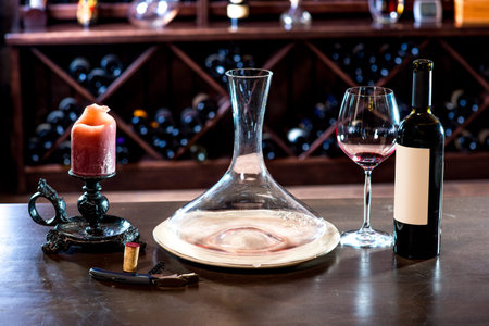 Decanter with wine and candle in the wine cellarの写真素材