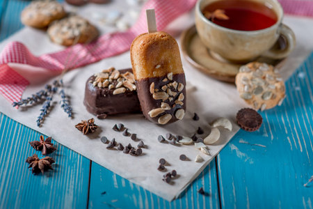 Sweet cookies and a cup of red tea with chocolate on blue wooden table