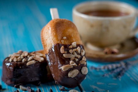 Sweet cookies and a cup of red tea with chocolate on blue wooden tableの写真素材