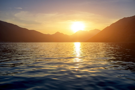 Sunset at the sea with mountains on backgroundの写真素材