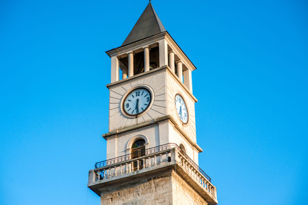 Clock tower on the blue sky background in Tirana, Albania. Close up view