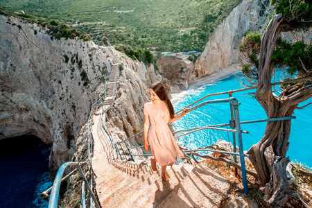 Young and beautiful woman walking on the rocky island beach in Greeceの写真素材