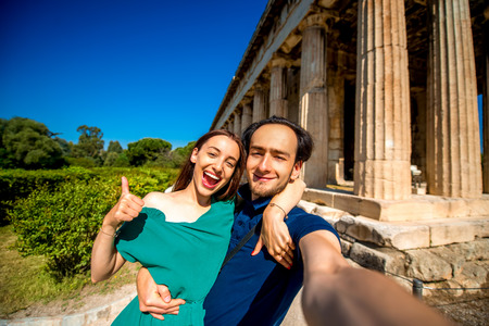 Young couple taking selfie picture with Hephaistos temple on background in Agora near Acropolis in Athens, Greeceの写真素材