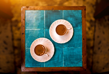 Two cups with black turkish coffee on the turquoise table in the cafeの写真素材