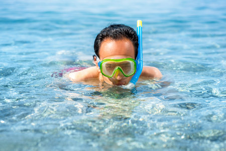 Man swimming with snorkeling mask in the blue and clear sea