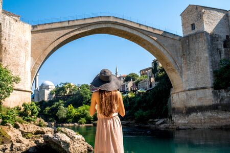 Beautiful woman tourist standing near the old bridge in Mostar city in Bosnia and Herzegovina.の写真素材