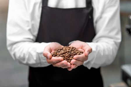 Male hands holding roasted coffee beans. Close up viewの写真素材