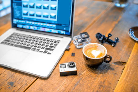 Small action video camera with coffe cup and laptop on the wooden tableの写真素材