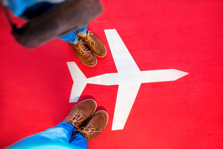 Airplane sign with couple's legs on the red background. Departure concept