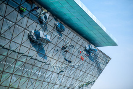 Modern airport terminal facade with cars and people's reflections
