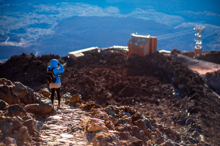 Beautiful landscape view from the top of volcano Teide with woman on the footpath and elevator on...