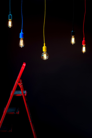 Illuminated lamps in colorful plafonds with red ladder on the dark background. Interior repair conceptの写真素材