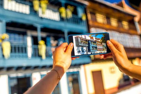Female hands photographing with smart phone old colorful balconies in Santa Cruz de la Palma in Spainの写真素材