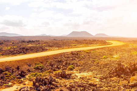 Ground road at Corralejo dunes with mountains on the background on Fuerteventura island in Spainの写真素材