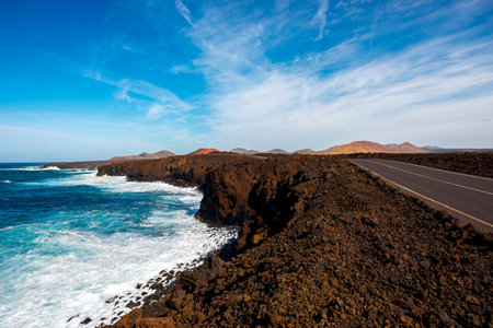 Volcanic Los Hervideros coastline with wavy ocean and road on Lanzarote island in Spainの写真素材