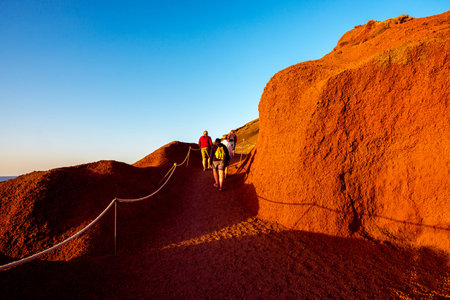 Footpath to El Golfo bay with tourists walking on the sunset on Lanzarote island in Spain