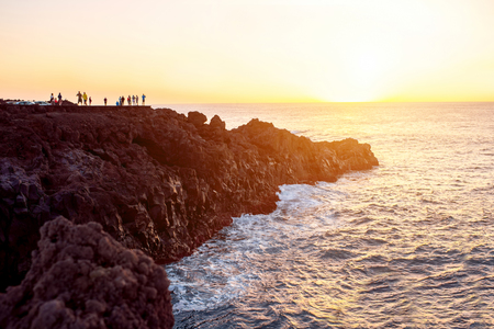 Los Hervideros rocky coast with tourists on the sunset on Lanzarote island in Spainの写真素材