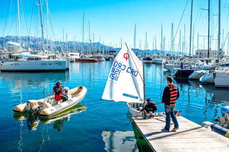 SPLIT, CROATIA - CIRCA APRIL 2015: Young boy practicing on the sailing boat with his father and teacher at the marine in Split, Croatia. Sailing and yachting is popular activity in Croatiaのeditorial素材