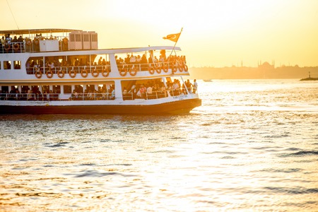 ISTANBUL - MAY 28, 2015: Ferry full with tourists floats on Bosphorus waterway in Istanbul on the sunset. Ferry in Istanbul is very popular transport connecting European and Asian part of the cityのeditorial素材
