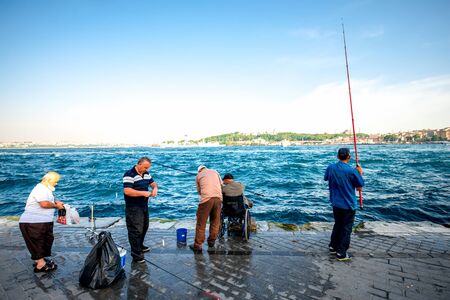 ISTANBUL - MAY 28, 2015: Turkish men fishing in Bosphorus waterway near Galata bridge in Istanbul. Hundreds of fishermen likes fishing in Istanbul all day longのeditorial素材