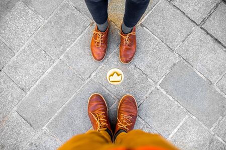 Couple standing near the small crown symbol on the sidewalk in Bratislava city in Slovakiaの写真素材