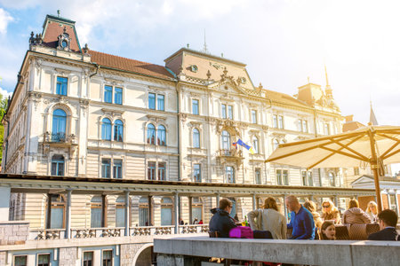Ljubljana, Slovenia - May 6, 2016: People sit at the cafe near Ljubljanica river in the old city centre in Ljubljana. Ljubljana is a popular tourist destination in Europe.のeditorial素材