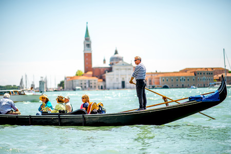 Venice, Italy - May 18, 2016: Gondoliers sail on gondolas full of tourists with San Georgio Maggiore island on the background in Venice.のeditorial素材