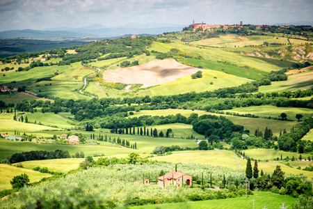 Beautiful tuscan landscape view on the green meadow with farmlands near Montepulciano town in Italyの写真素材