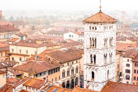 Aerial cityscape view on the old town of Lucca with San Michele basilicas tower at the foggy weather in Italyの写真素材