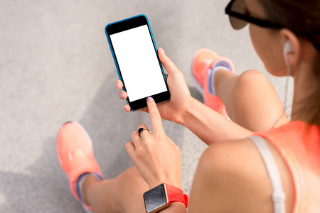 Sports woman holding a smart phone with empty screen to copy paste. Mobile phone program for sportの写真素材