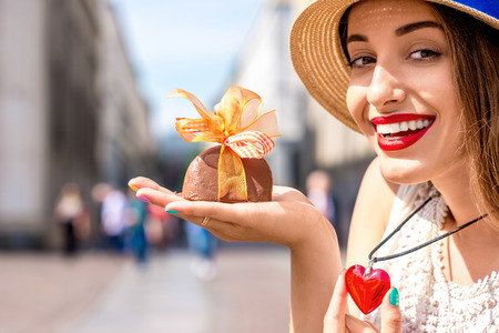 Young woman holding italian chocolate with bow on Turin city background. Turin in Piedmont region in Italy is famous of its chocolate makingの写真素材